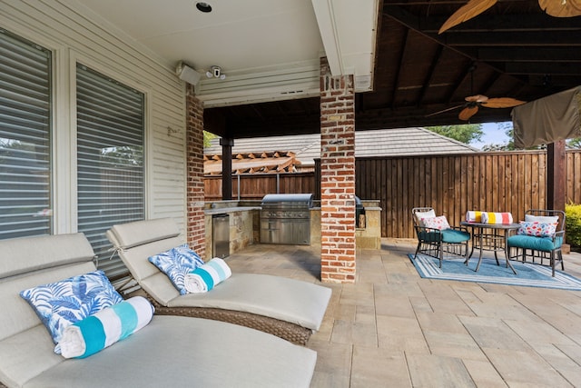 view of patio with grilling area, ceiling fan, and an outdoor kitchen