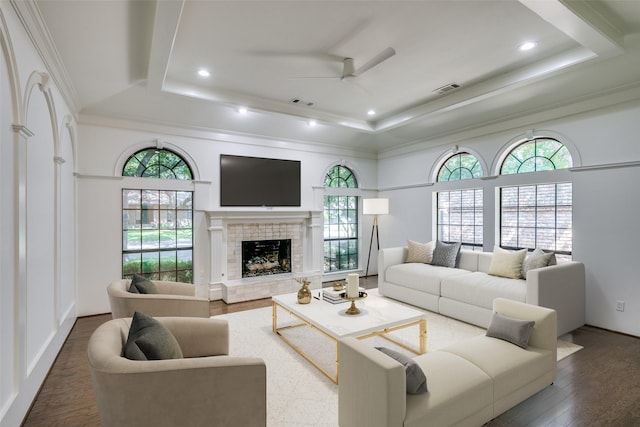 living room with hardwood / wood-style floors, ceiling fan, a fireplace, and a tray ceiling