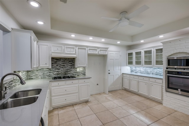 kitchen with light tile patterned flooring, appliances with stainless steel finishes, white cabinetry, and sink