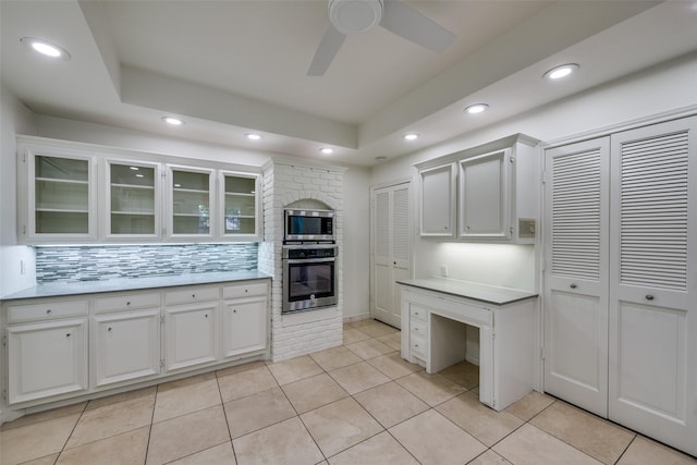 kitchen featuring backsplash, white cabinets, ceiling fan, light tile patterned flooring, and stainless steel appliances