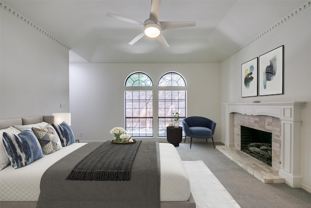 carpeted bedroom with a tile fireplace and ceiling fan