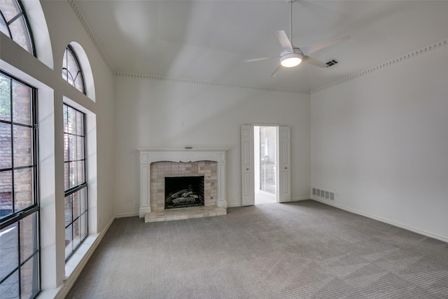 unfurnished living room featuring carpet flooring, ceiling fan, and a towering ceiling