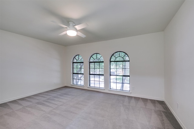 carpeted spare room featuring ceiling fan