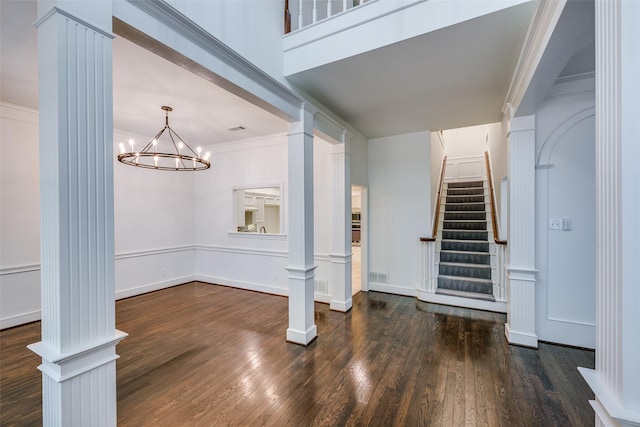 interior space with ornate columns, ornamental molding, and a chandelier