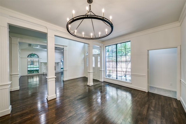 dining space with an inviting chandelier, crown molding, dark wood-type flooring, and decorative columns