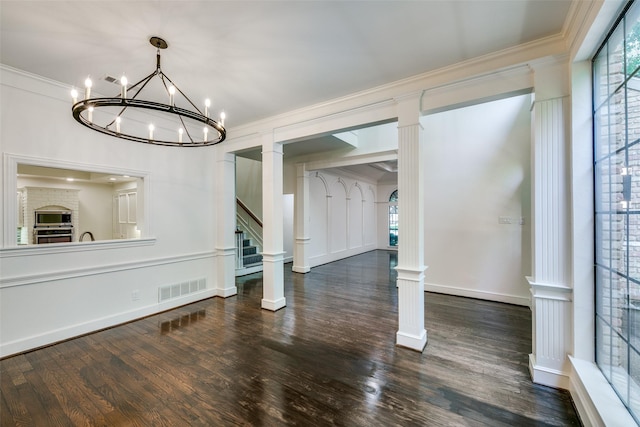 unfurnished dining area featuring dark wood-type flooring, ornamental molding, and a notable chandelier