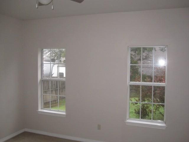 carpeted spare room with ceiling fan