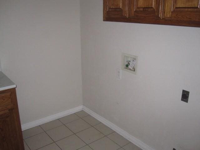 washroom featuring light tile patterned flooring, cabinets, and washer hookup