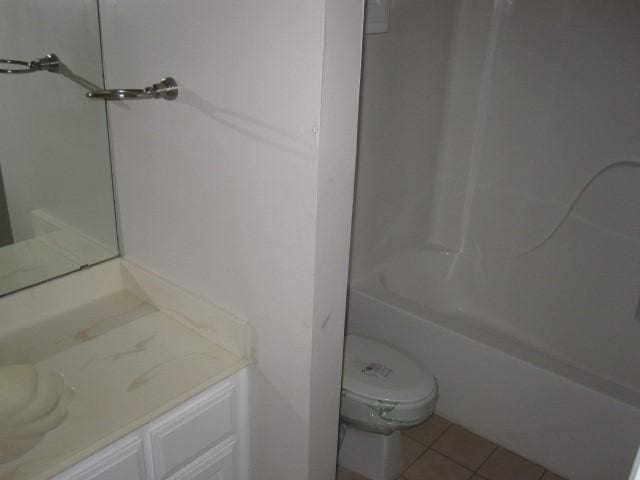 full bathroom with bathing tub / shower combination, tile patterned flooring, vanity, and toilet