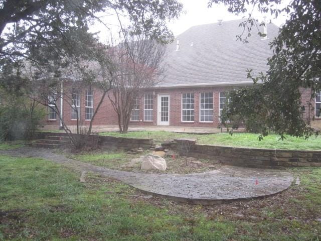 rear view of house featuring a lawn