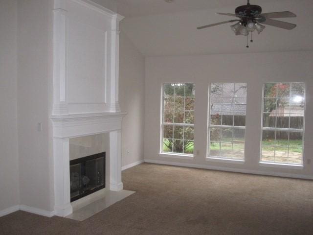 unfurnished living room featuring a fireplace, carpet, ceiling fan, and a healthy amount of sunlight