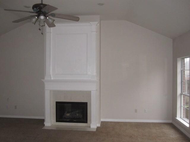 unfurnished living room with carpet, ceiling fan, a large fireplace, and lofted ceiling