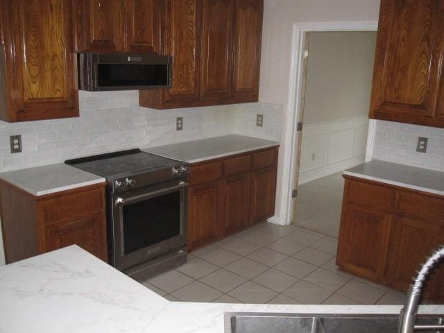 kitchen with backsplash and stainless steel range with electric stovetop