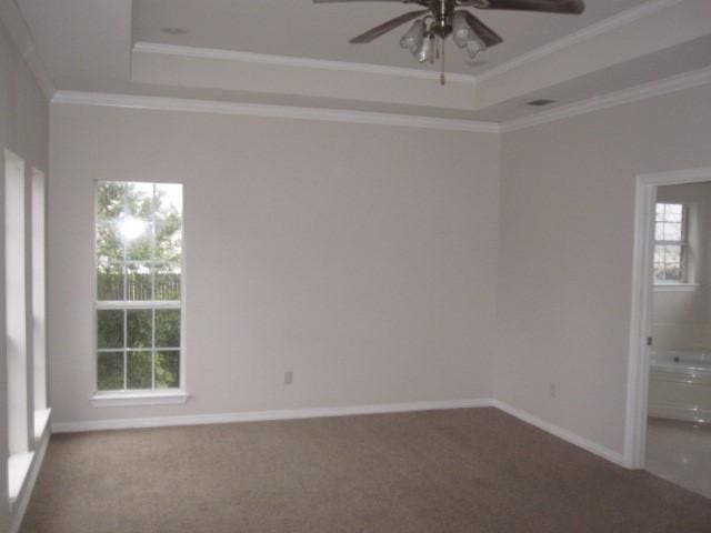 carpeted empty room featuring ceiling fan, crown molding, and a tray ceiling