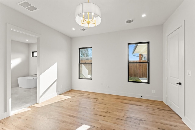 unfurnished bedroom with light hardwood / wood-style flooring and an inviting chandelier