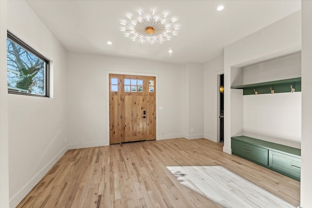 entryway with light hardwood / wood-style flooring and a notable chandelier