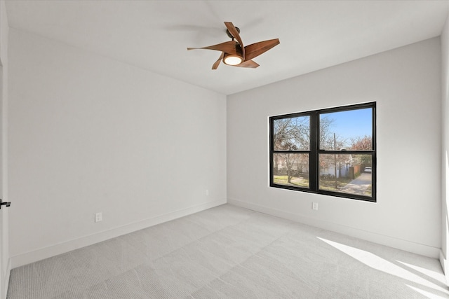 spare room with ceiling fan and light colored carpet