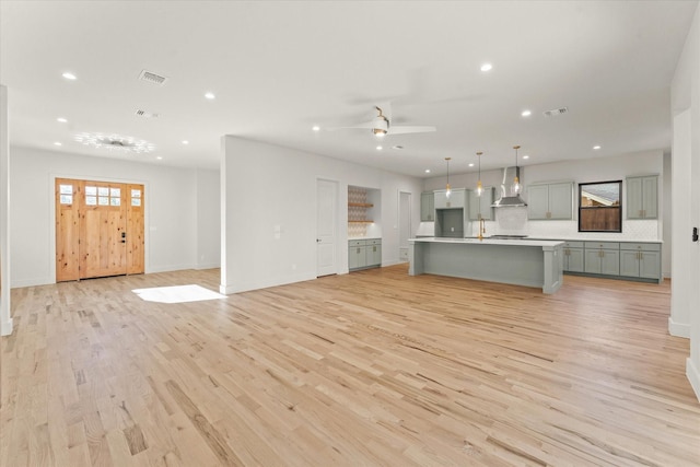 unfurnished living room with ceiling fan and light hardwood / wood-style floors