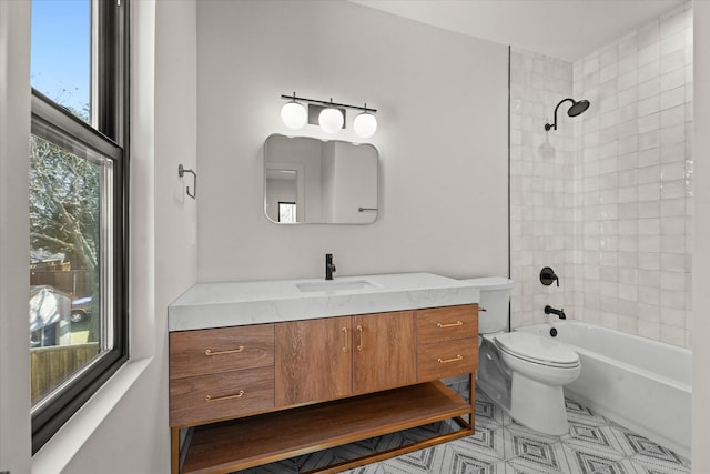 full bathroom featuring vanity, tiled shower / bath combo, plenty of natural light, and toilet