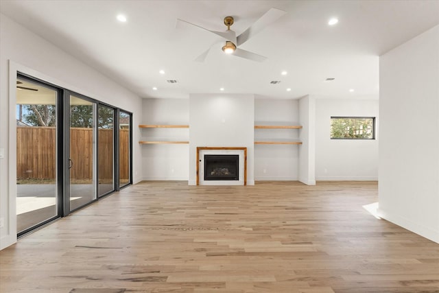 unfurnished living room featuring ceiling fan, light hardwood / wood-style floors, and a wealth of natural light