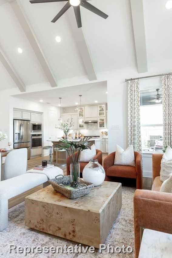 living room featuring ceiling fan, beamed ceiling, and high vaulted ceiling