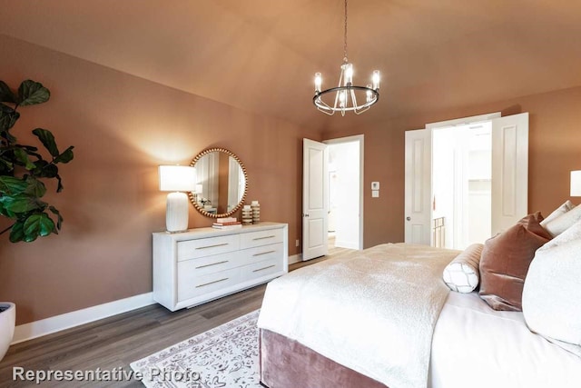 bedroom with an inviting chandelier and dark hardwood / wood-style flooring