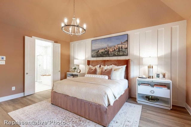 bedroom with connected bathroom, wood-type flooring, and a chandelier