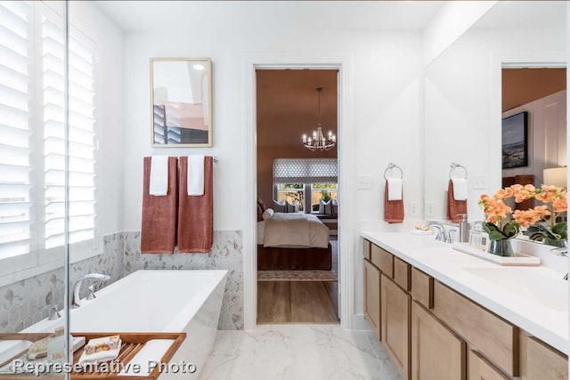 bathroom featuring a tub to relax in, plenty of natural light, vanity, and a chandelier