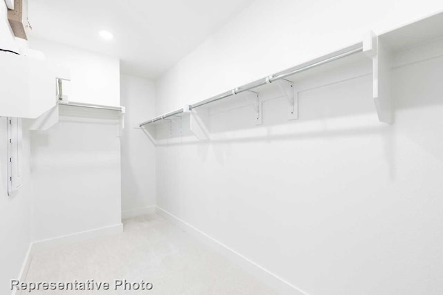 walk in closet with light colored carpet