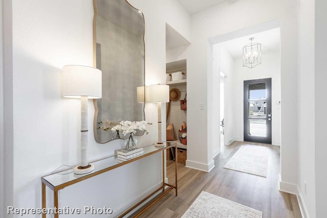 foyer entrance featuring a chandelier and light hardwood / wood-style floors