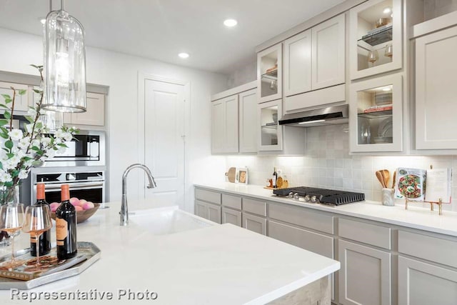 kitchen featuring sink, ventilation hood, hanging light fixtures, stainless steel appliances, and backsplash