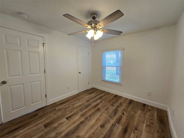 unfurnished bedroom with ceiling fan and dark hardwood / wood-style flooring