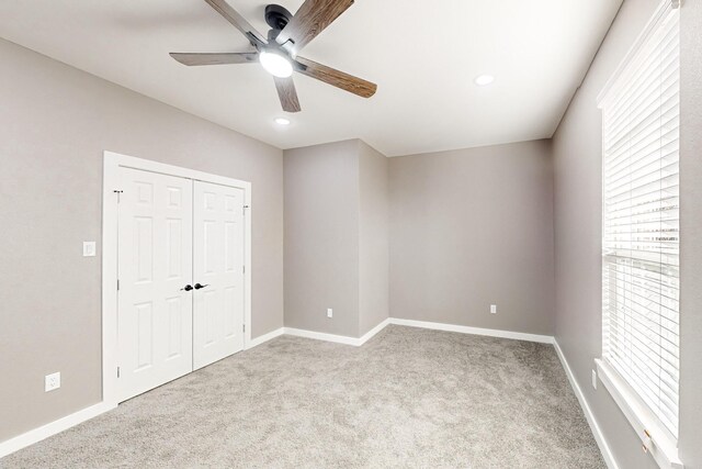 unfurnished bedroom with light colored carpet and ceiling fan