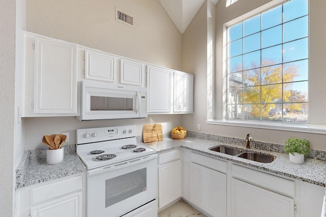 kitchen featuring white cabinetry, white appliances, sink, and vaulted ceiling