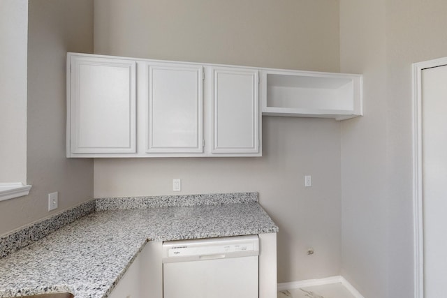 interior space with dishwasher, white cabinets, and light stone counters