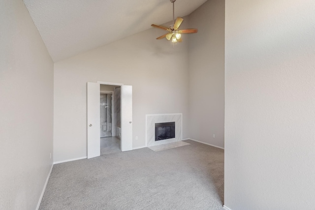 unfurnished living room with ceiling fan, a fireplace, carpet floors, and high vaulted ceiling