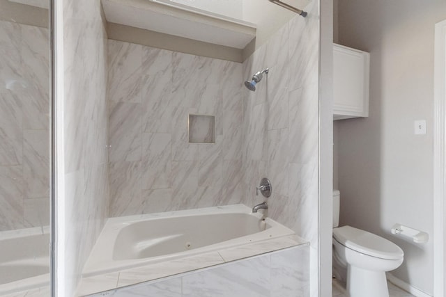 bathroom featuring tiled shower / bath combo and toilet