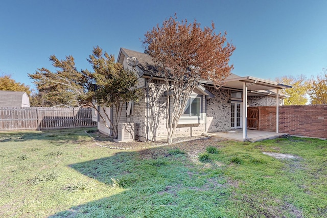 rear view of property featuring a yard and a patio