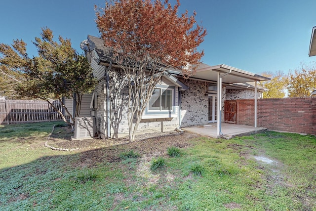 back of property with a yard and a patio