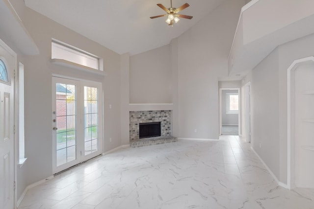 unfurnished living room featuring ceiling fan and a brick fireplace