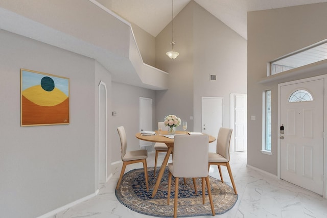 dining room with high vaulted ceiling