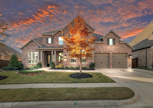 traditional-style home with brick siding, driveway, an attached garage, and a front lawn