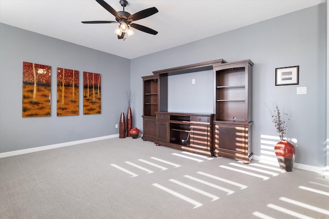 unfurnished living room featuring carpet flooring, ceiling fan, and baseboards