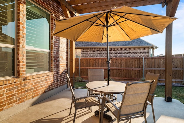 view of patio with outdoor dining space and fence