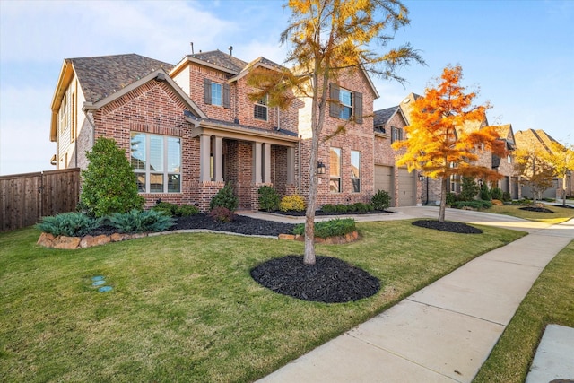 view of front facade featuring brick siding, a front lawn, fence, a garage, and driveway