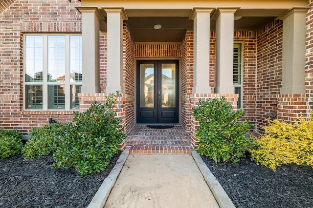 view of exterior entry with french doors and brick siding