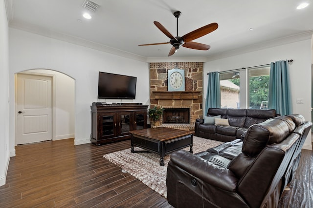 living room with dark hardwood / wood-style flooring, crown molding, a fireplace, and ceiling fan