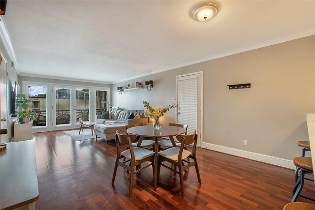 dining space with baseboards, visible vents, dark wood-style flooring, and crown molding