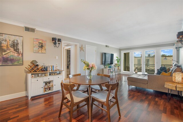 dining space with baseboards, visible vents, dark wood finished floors, and crown molding