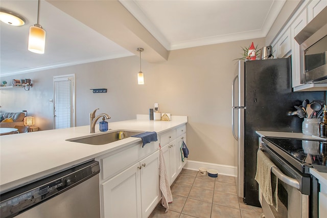 kitchen with appliances with stainless steel finishes, light countertops, a sink, and pendant lighting